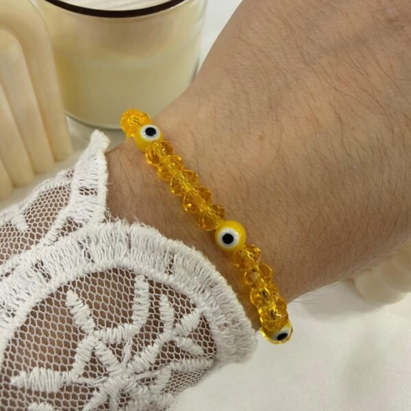 pulsera amarilla extensible con ojitos varios